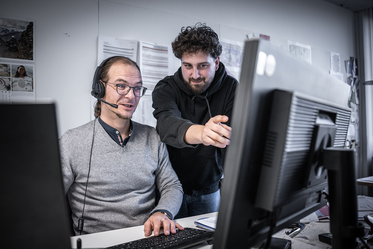 Kollegialer Austausch vor dem PC